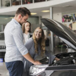 smiling-woman-checking-car-engine